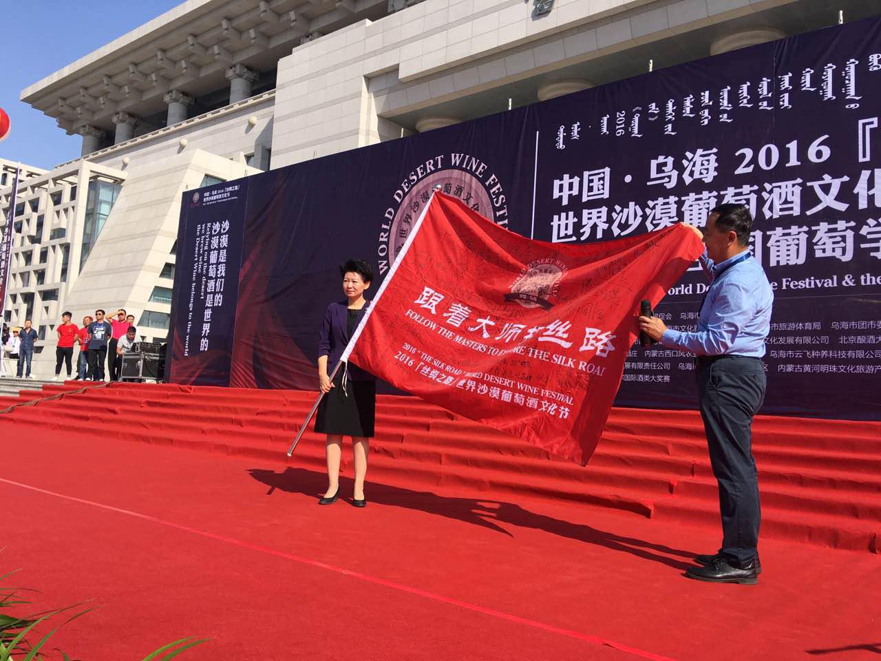 葡萄酒专家郭松泉向冀晓青副市长移交“跟着大师探丝路”队旗